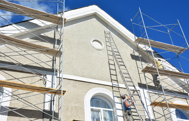 Contractor preparing to paint exterior stucco